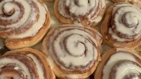 Close-up of frosted cinnamon rolls in a baking dish