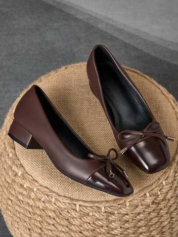 Pair of navy blue square-toe pumps with a bow detail and block heel